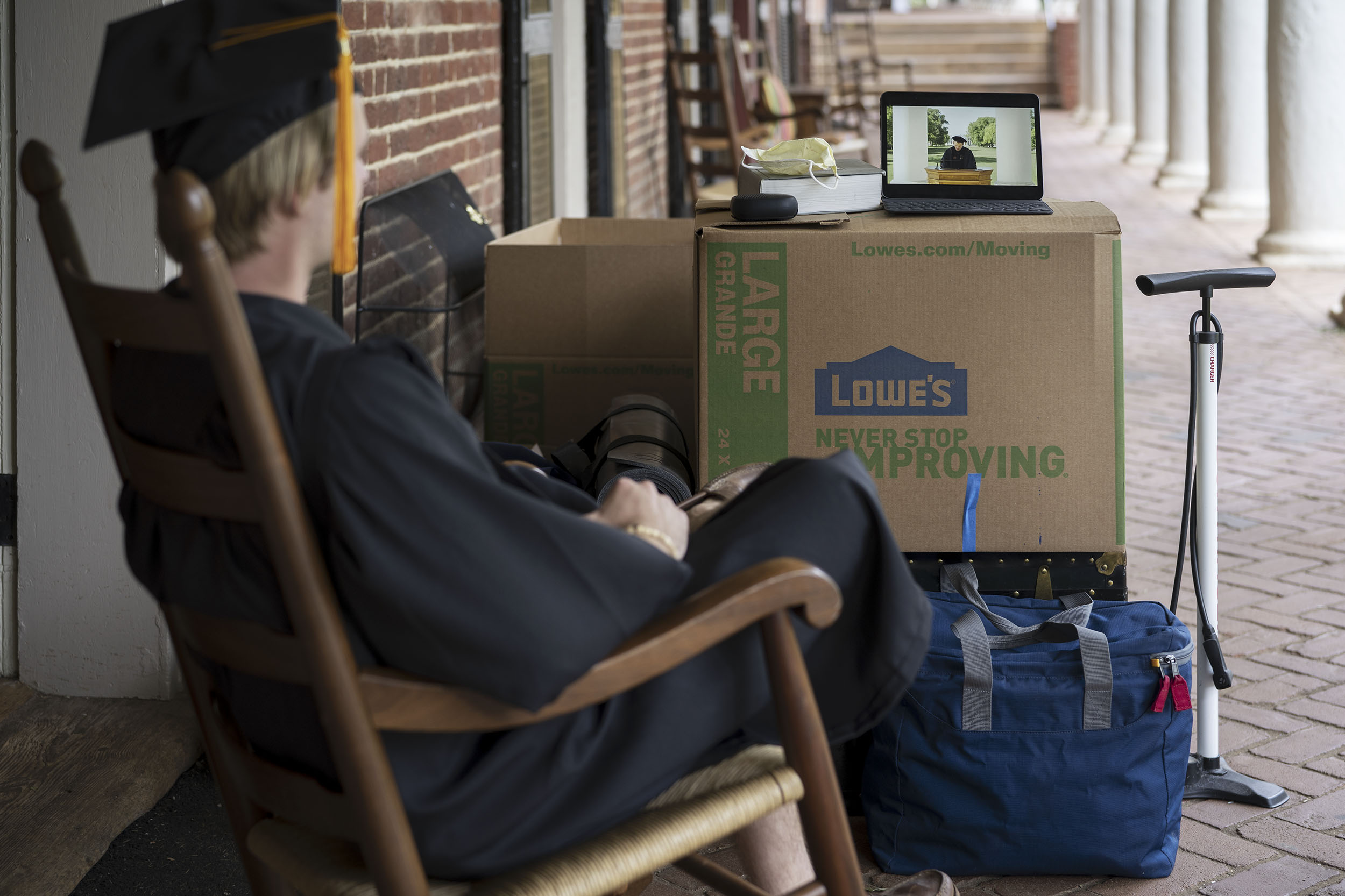 Almost nothing about graduating in 2020 was normal, but this graduate did manage to don a cap and gown while watching the virtual commencement celebration on the Lawn. (Photo by Sanjay Suchak, University Communications)