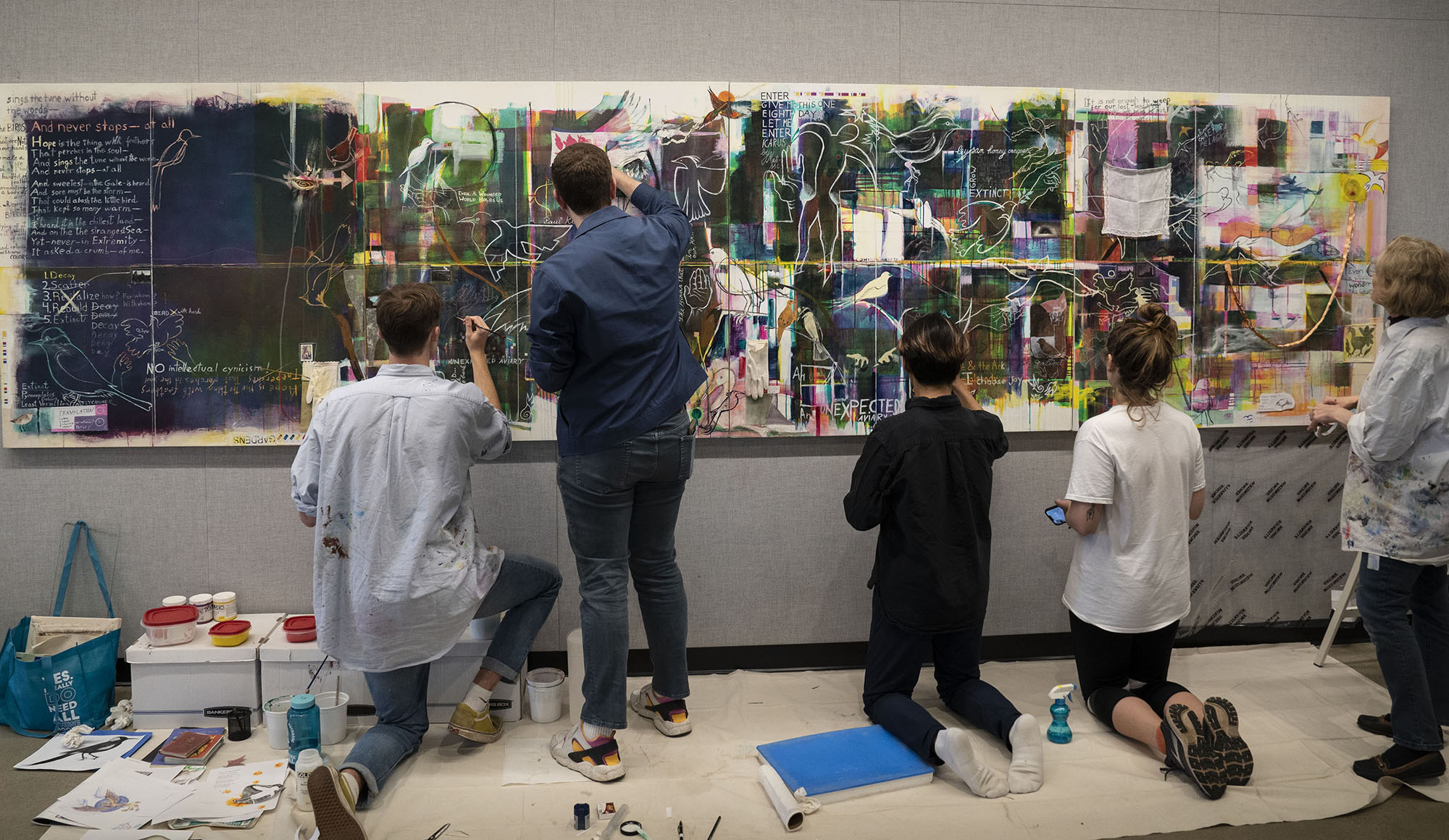 An image of five people working on a painting