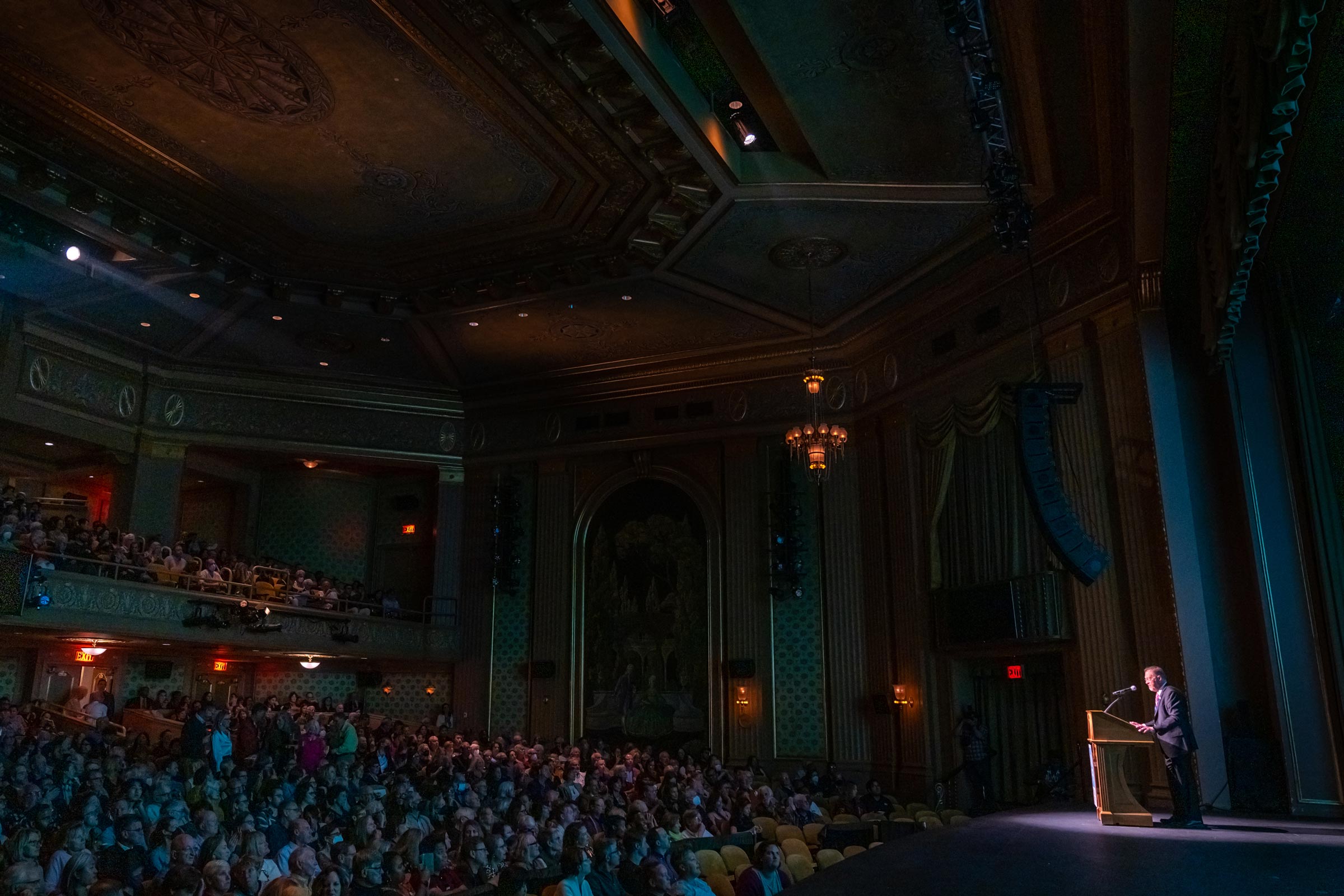 A crowd in the Paramount Theater watches as Film Festival Director Jody Kielbasa delivers a speech.