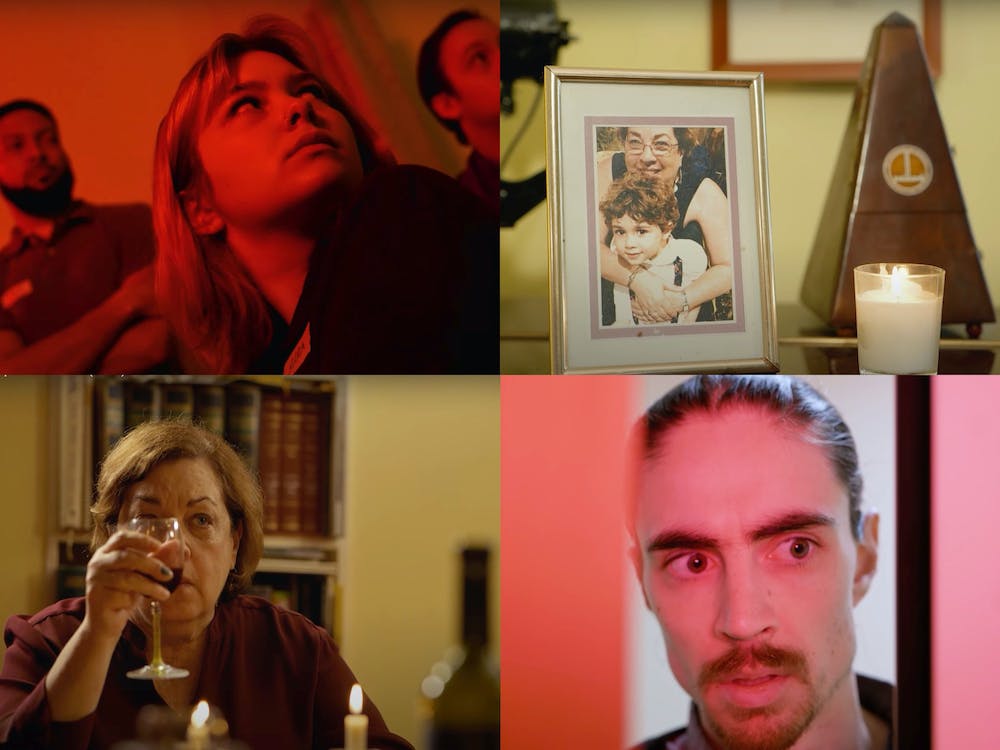 Top left: three people look up and to their left while bathed in a red light. Top right: a framed photo of a woman and child next to a lit candle. Bottom left: a woman holds up a glass of wine in front of her face while sitting behind several lit candles. Bottom right: a man with a mustache looks to his left close to the camera.