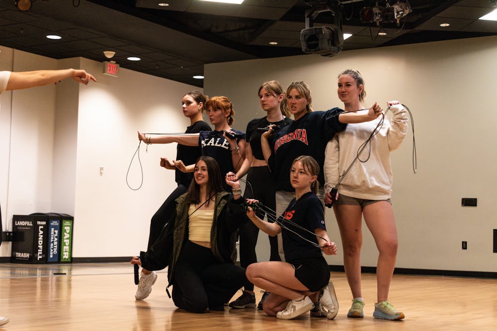 Seven performers pose in a dance formation while holding jump ropes.