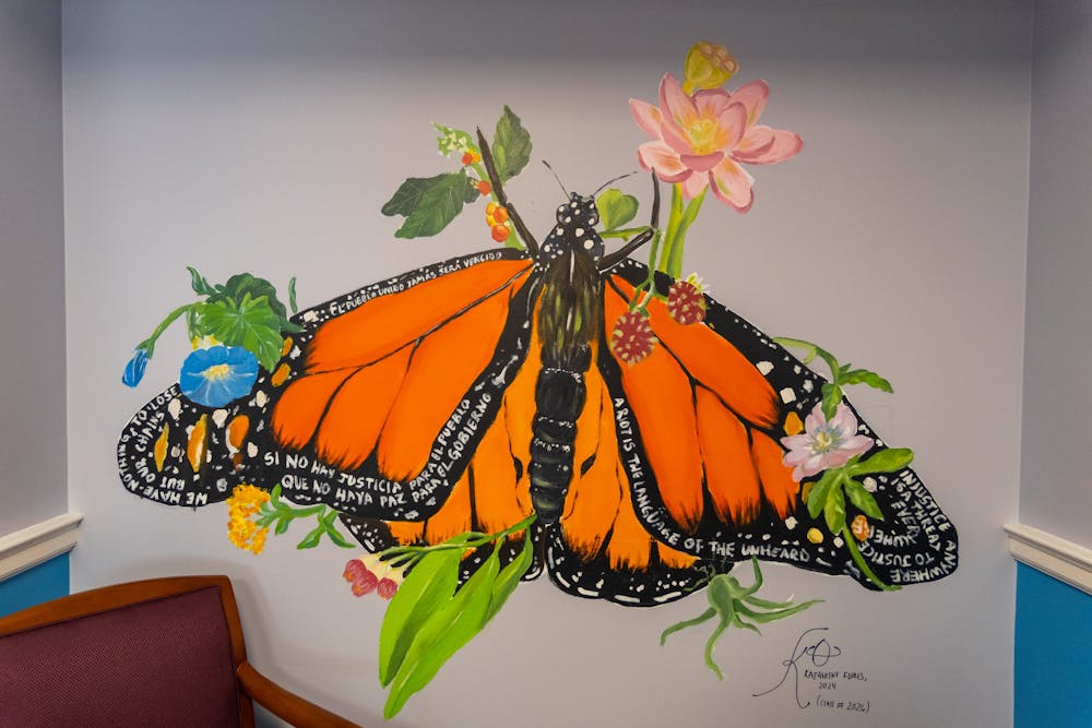 A mural of an orange monarch butterfly surrounded by several different species of plants.