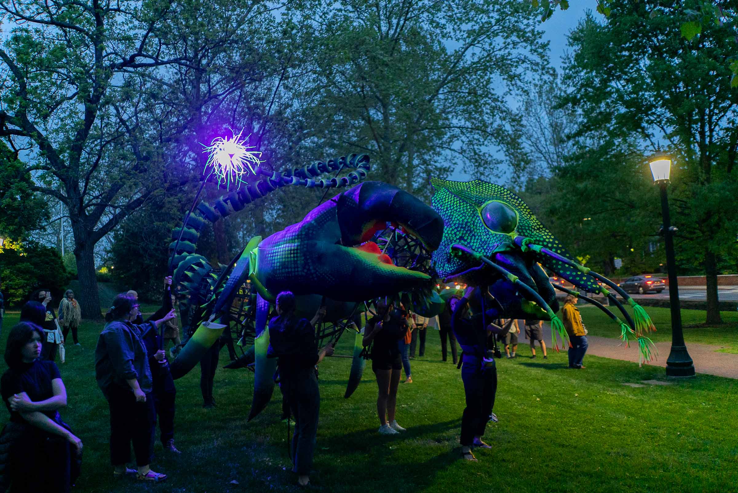 The crustacean puppet Kiki lights up the dusky sky on grounds with its embedded blacklights.