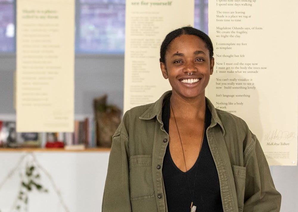 Artist and poet MaKshya Tolbert smiles at the camera.