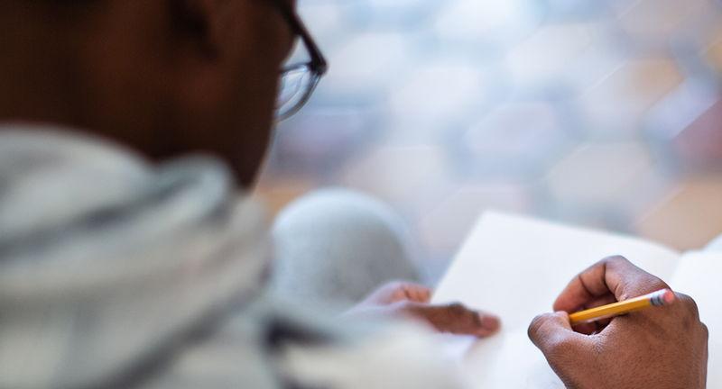 A person from the back, writing in a notebook