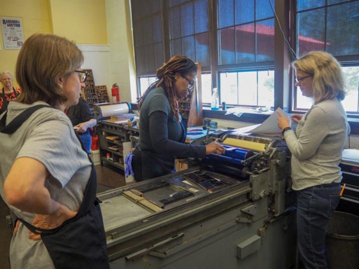 Three people working at a Letter Press